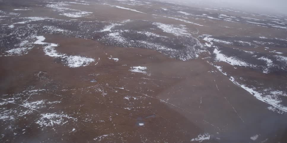 Rain streaks the window of a flying aircraft then clears