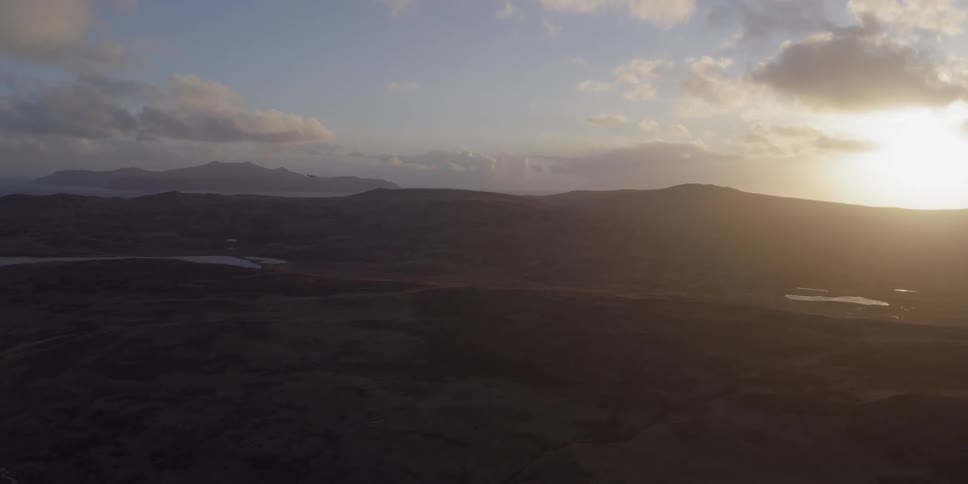 The sun sets over a mountain landscape