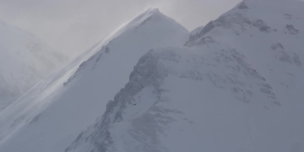 Wind blows snow on a mountain top