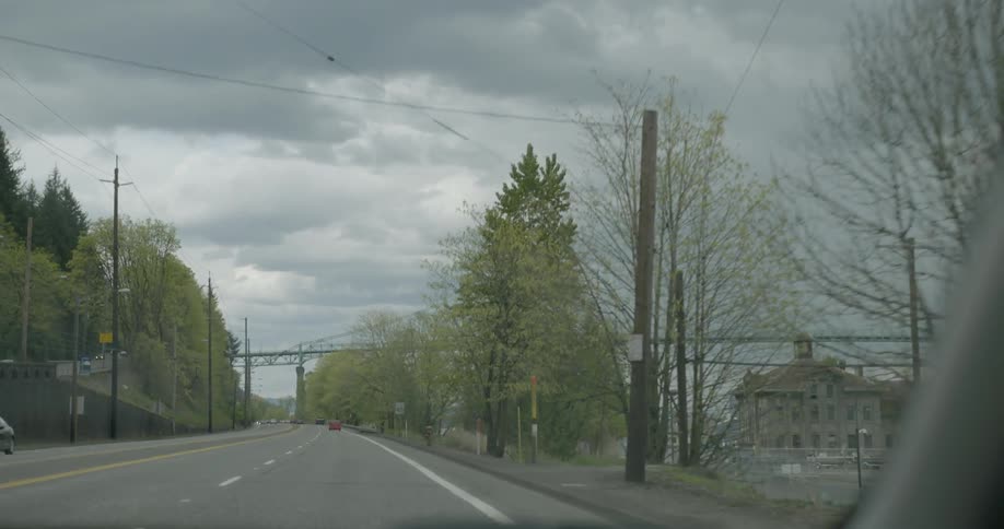 Car driving down a road on a cloudy day