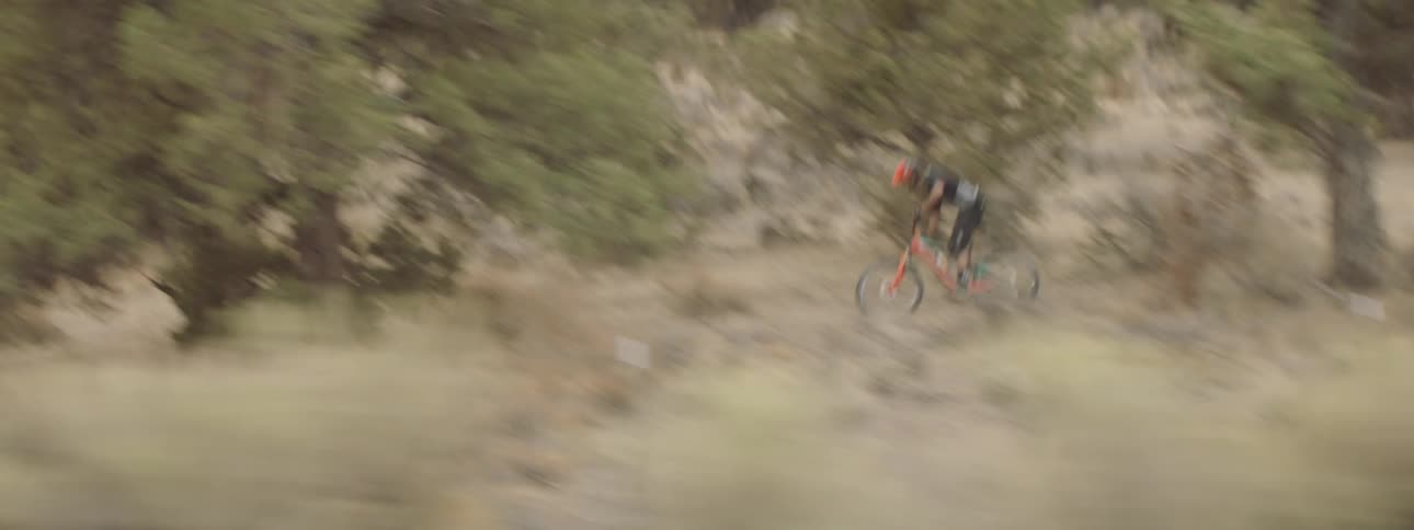 Man rides mountain bike over hilly terrain