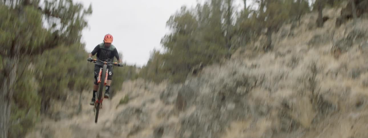 Person rides a bike over a bumpy dirt path