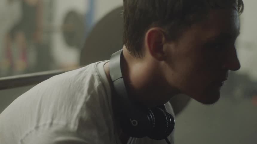 Man with headphones around his neck slowly looks forward