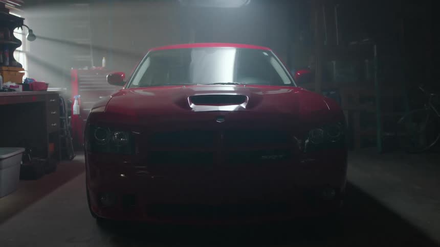 A man walks by a car parked in a garage