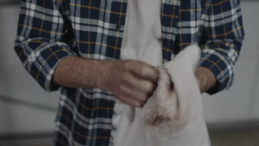 A man wipes oil off of his hand with a towel