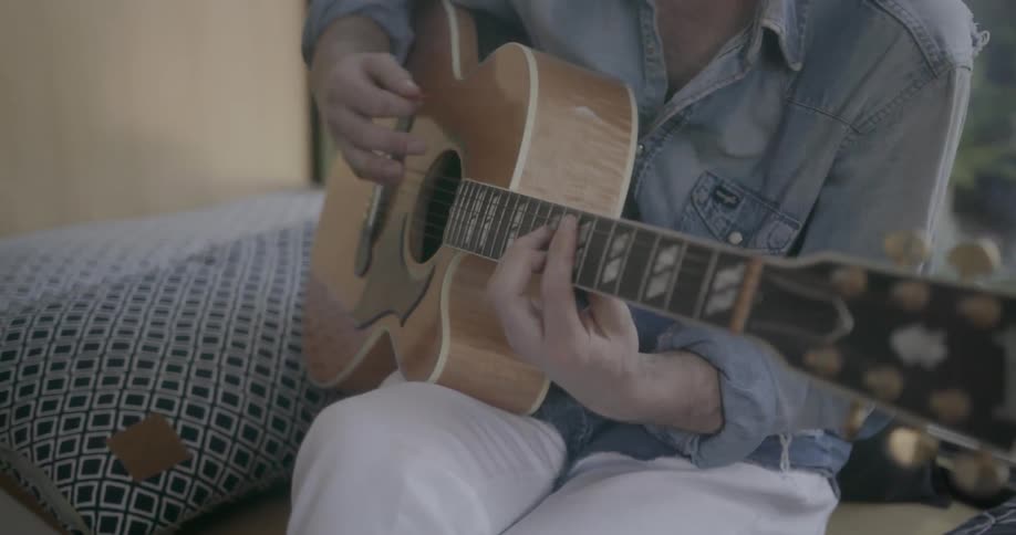 A man sings and plays acoustic guitar