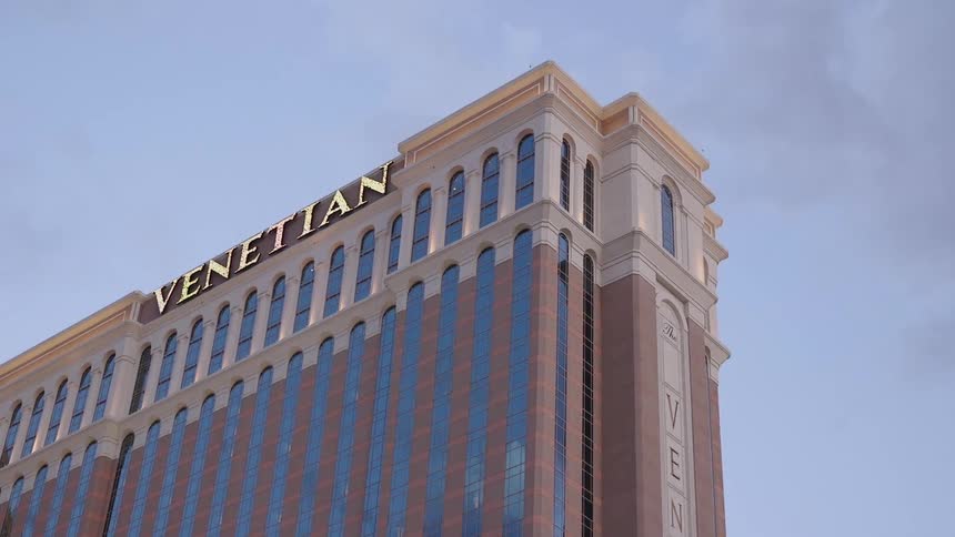 The tall building has a lit sign at the top