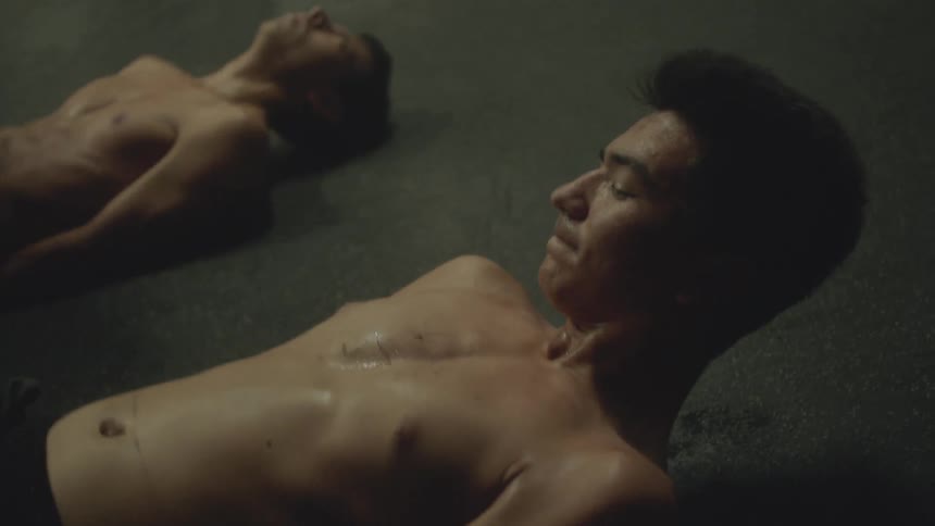 Men lying on the ground kicking their legs in the air exercising