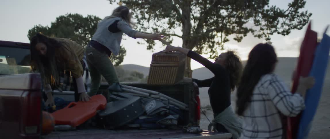 A group of women are getting supplies out of the back of a truck