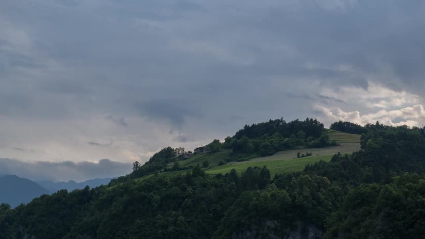 Clouds pass over a green hill