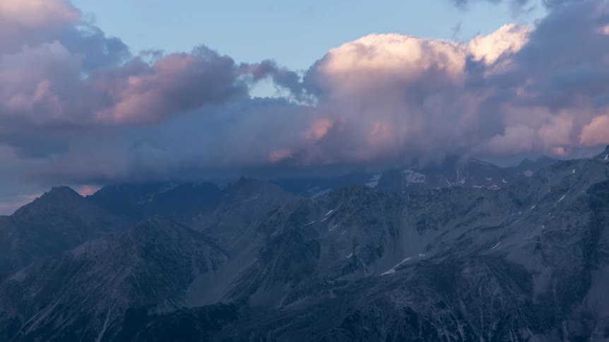Evening clouds pass over a mountain range