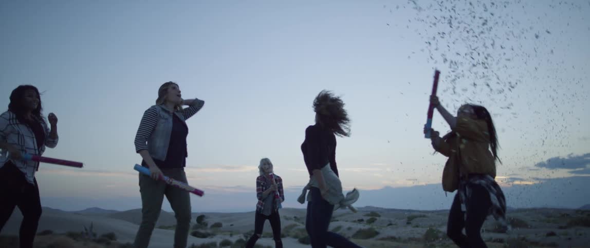 Friends sets off confetti cannon at sunset