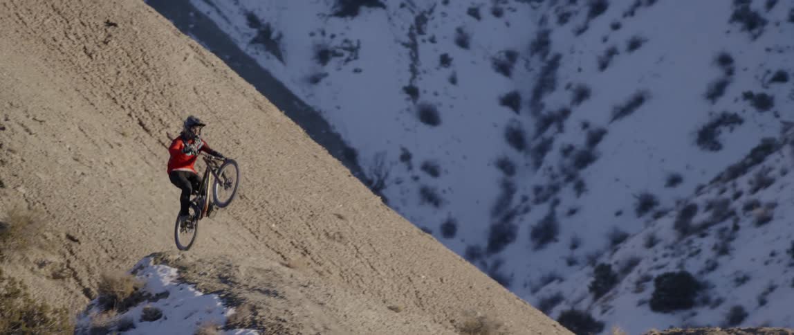 A man catches air off an embankment as he rides a mountain bike