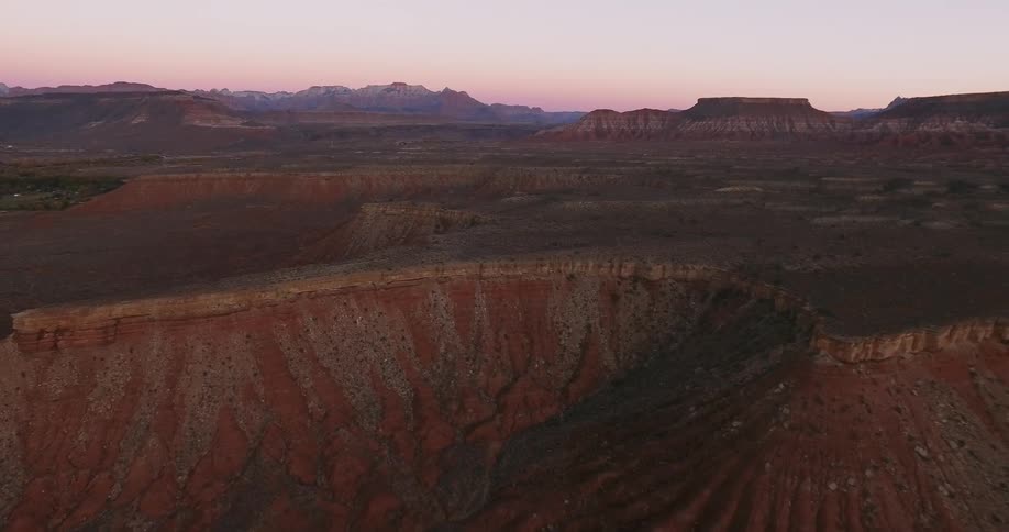 The sun is setting behind the canyons below