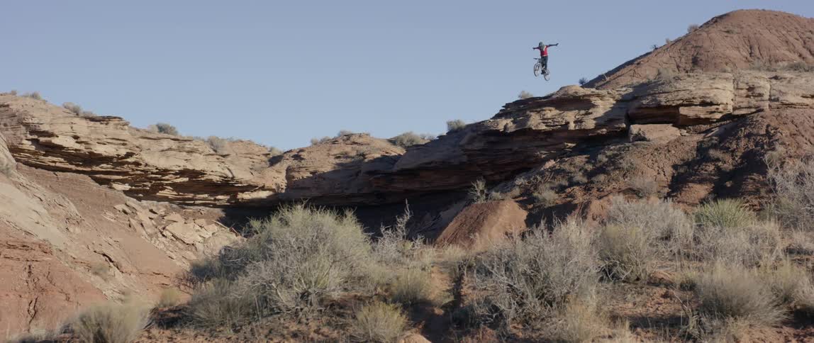 Person jumps a bike down a large ravine
