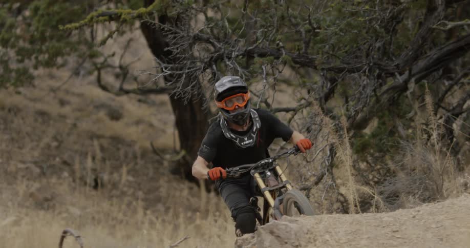 Man rides a bike over bumpy terrain