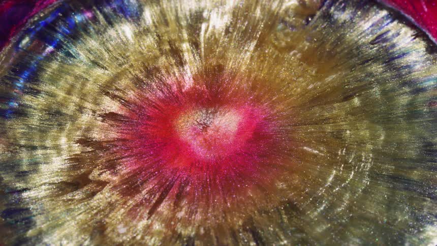 Colors and patterns are moving out from the center of a liquid body