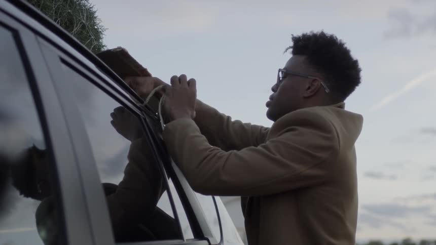 Man ties a pine tree to a car roof