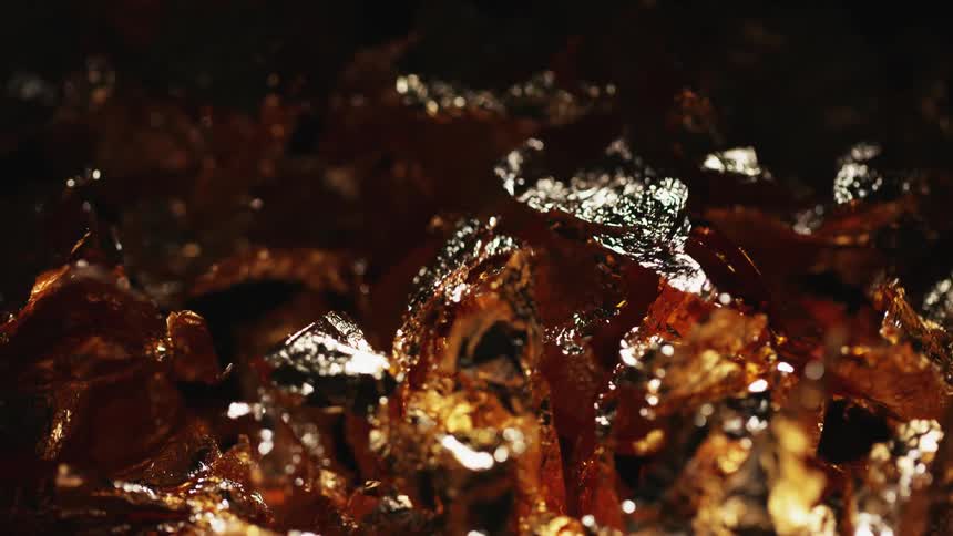 Flakes of gold material are shimmering and shaking