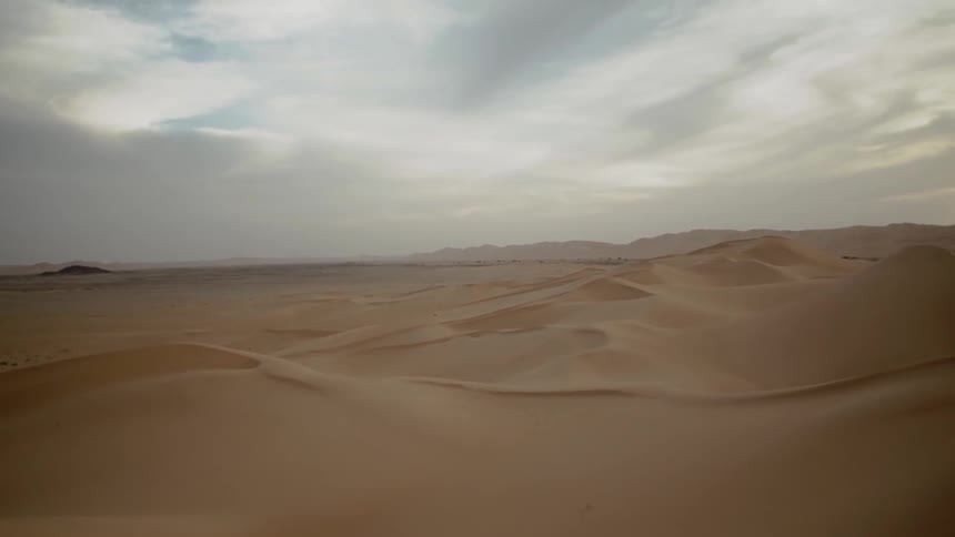 Clouds float over a sandy desert