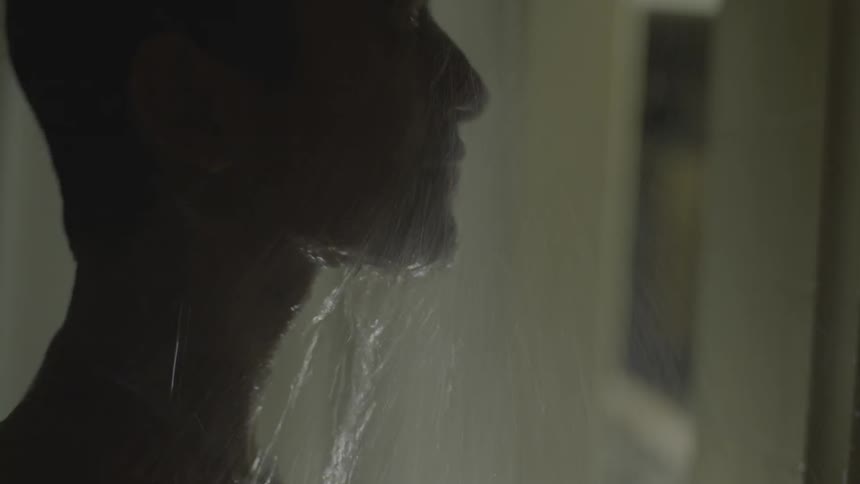 Man taking a shower in a dark area