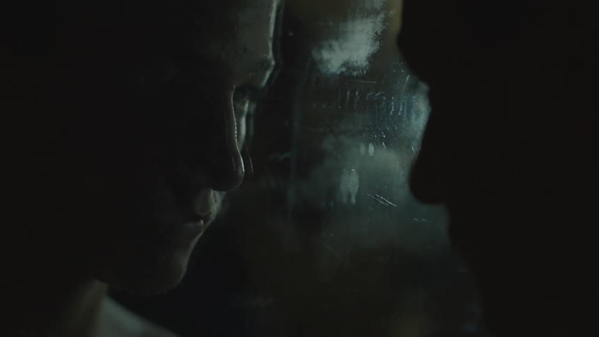 Man staring into a mirror in a dark area