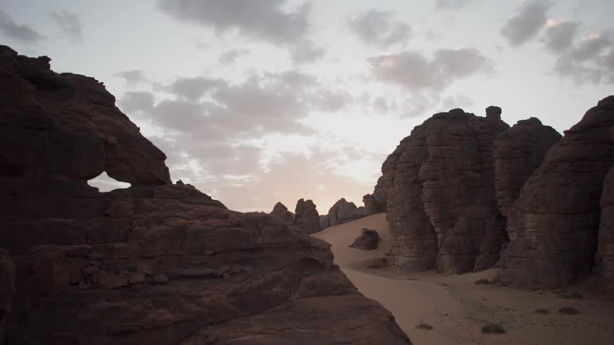 Clouds float over rock formations at sunset
