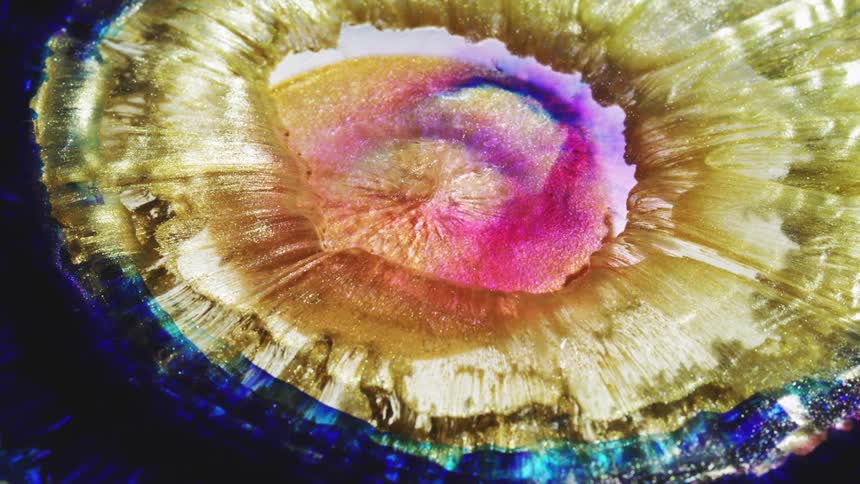 Colors and patterns are moving out from the center of a liquid body