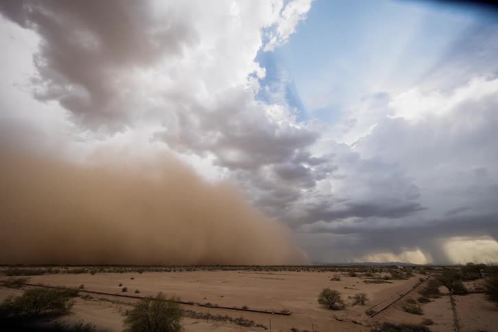 A dust storm approaches and engulfs the plains