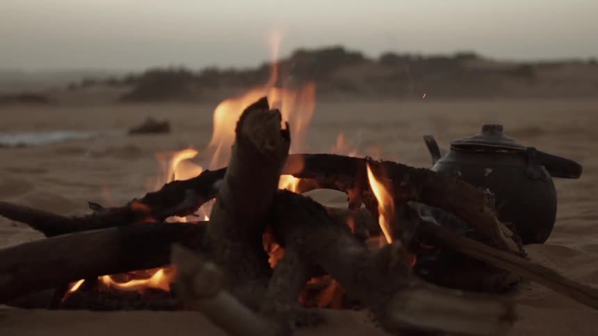A camp fire burns in the desert