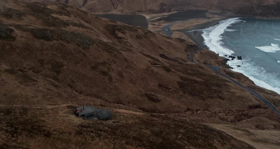 Hilly rocky terrain and bunker next to a body of water