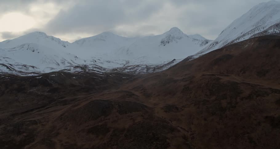 Clouds float over snowy mountain peaks