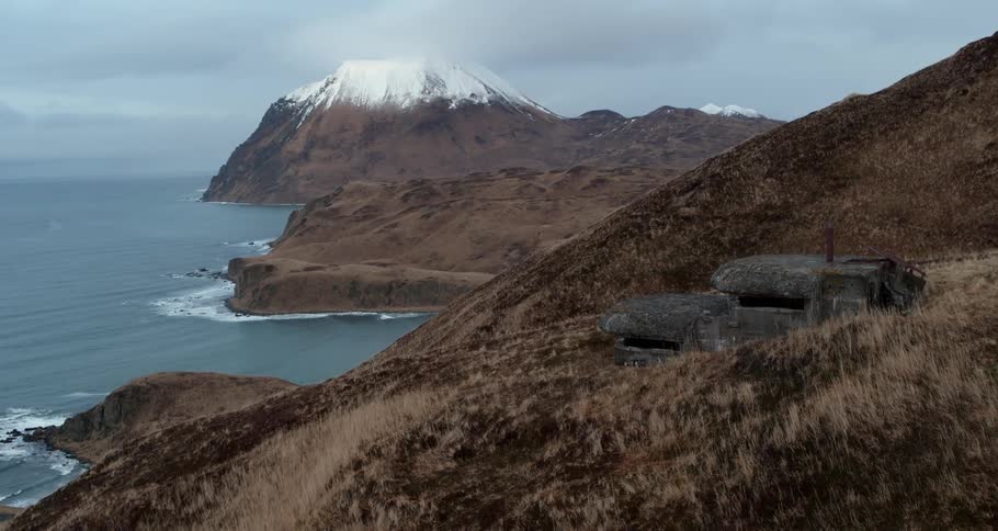 Water flows towards the mountain shore below a bunker
