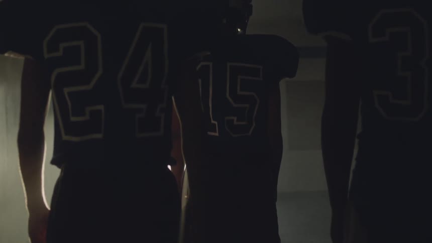 Players wearing jerseys stand in a hall together