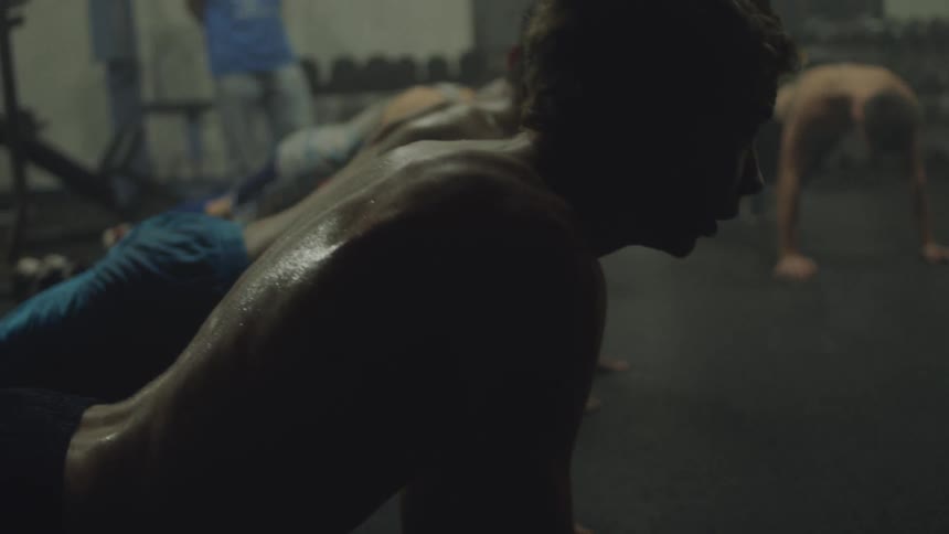 Group of men doing push ups in a gym