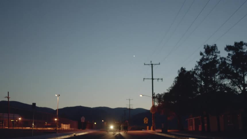 People running down a road at sunset
