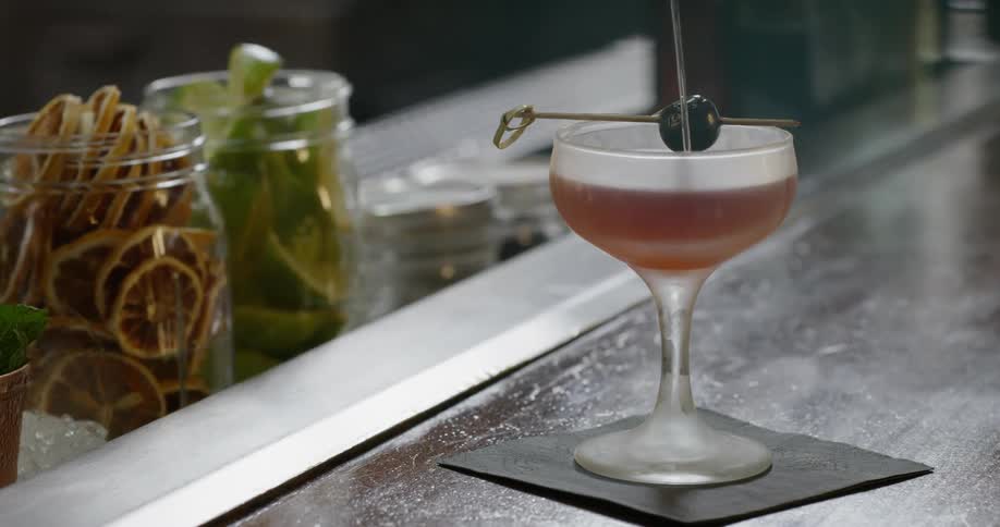 Alcohol is poured into a cocktail