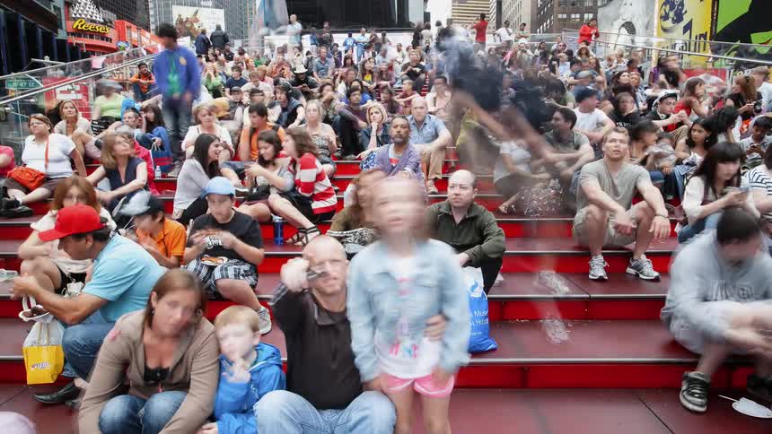People sit and eat on steps in a city