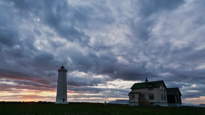 Clouds float over a rural house at sunset