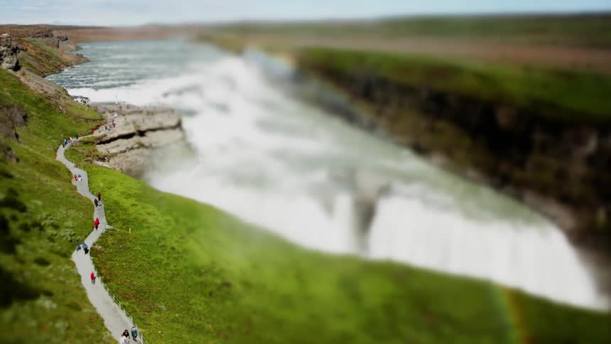 People walk near a waterfall