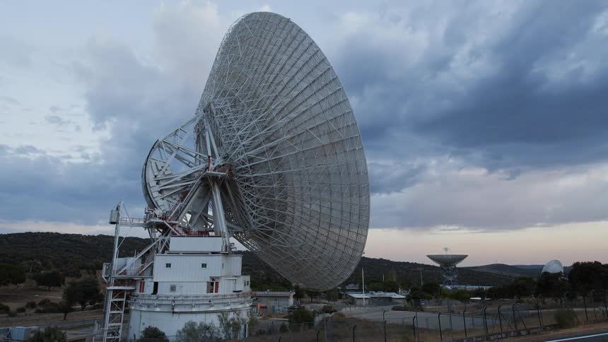 Clouds pass over large satellite dishes