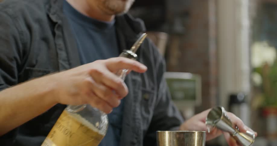 A bartender pours a drink