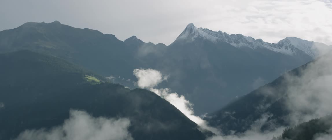 Clouds float around mountains