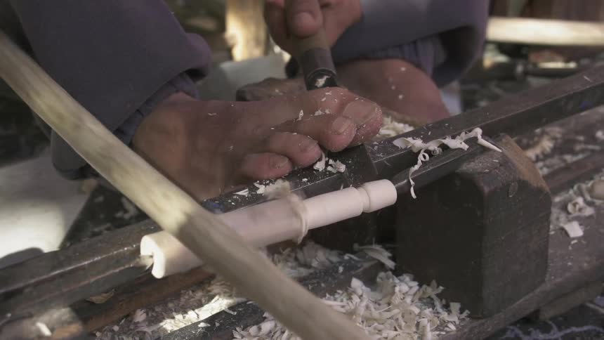 A man carves a piece of wood
