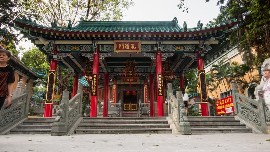 People are walking through a Chinese shrine during the day
