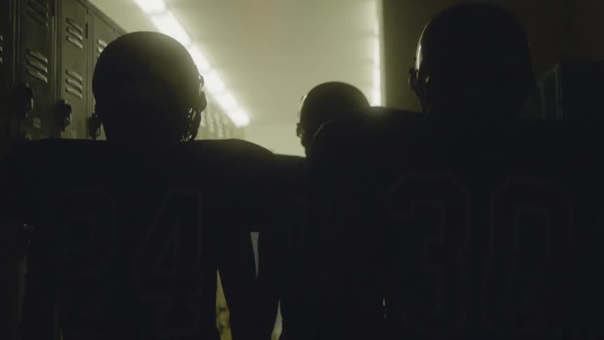Football players walking down a long hall