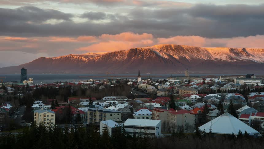 Clouds float over a mountain town at sunset