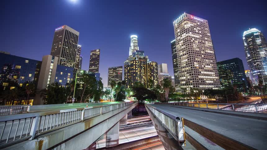 Cars drive on city streets at night