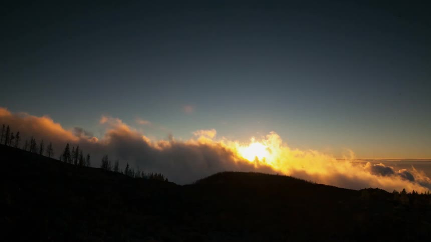 Clouds roll over the landscape at sunset