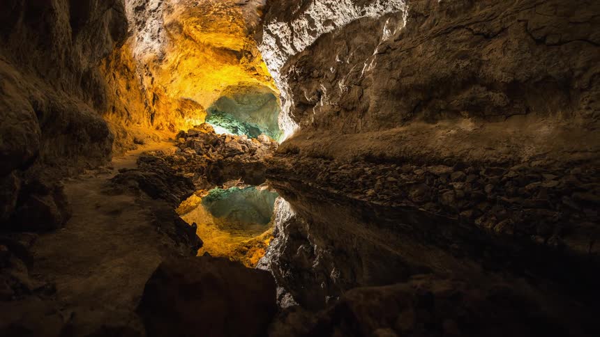A pool of water sits in a cave